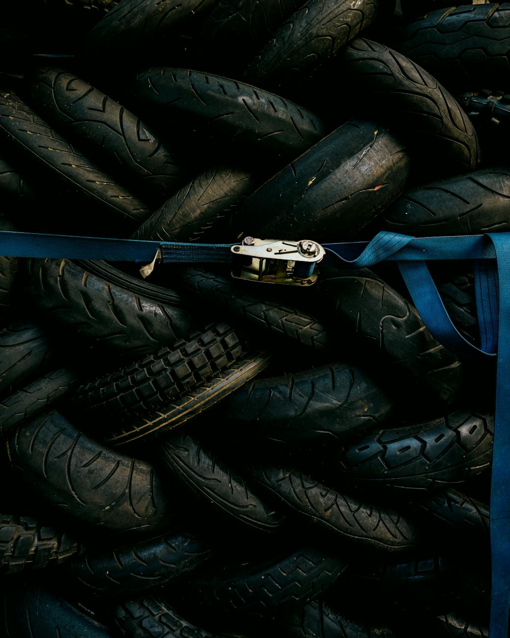 Home A pile of used tires strapped with a blue belt. Industrial and recycling theme.