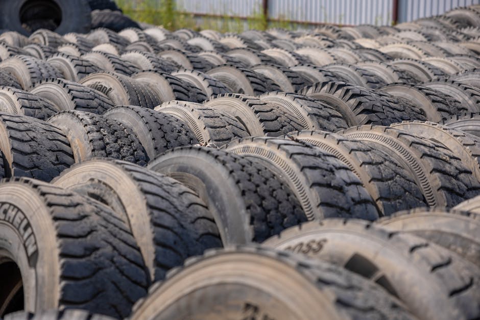 Home A large outdoor storage yard filled with rows of old tires, ideal for concepts like recycling or industrial use.